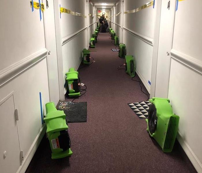 Hallway with green SERVPRO air movers. 