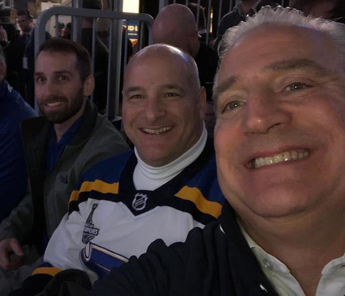 Four men smiling at a camera.