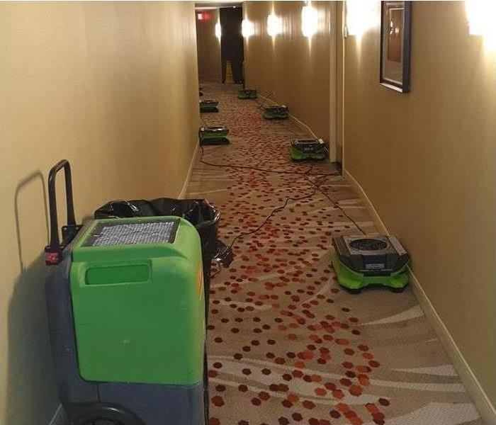 air movers placed alongside hallway of a commercial building